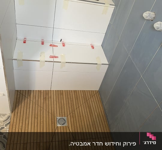 אריחים מותקנים עם סרט דבק וכלי עבודה